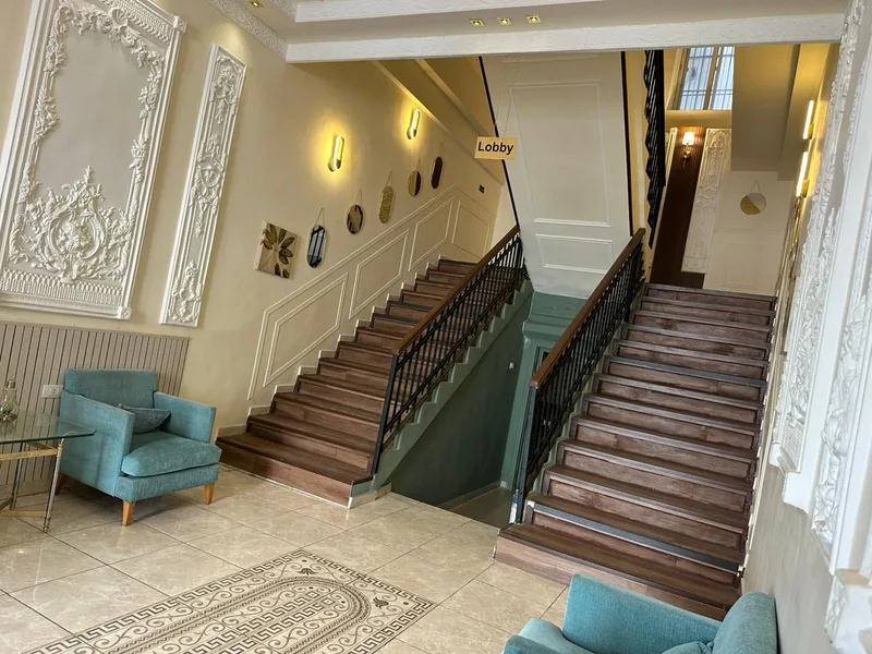 The two wooden staircases in the City Citadel lobby, between moulded plaster panels
